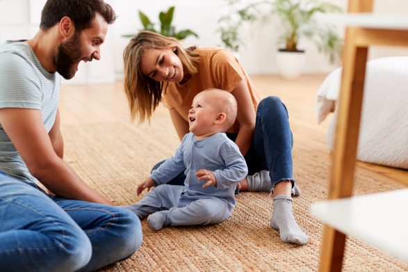 young couple playing on floor with baby